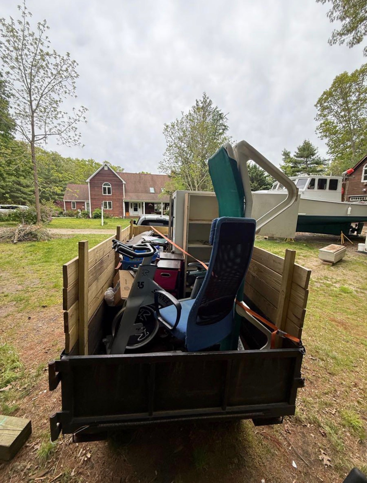 Trailer fully loaded with furniture, office chair, and outdoor gear after a residential cleanout